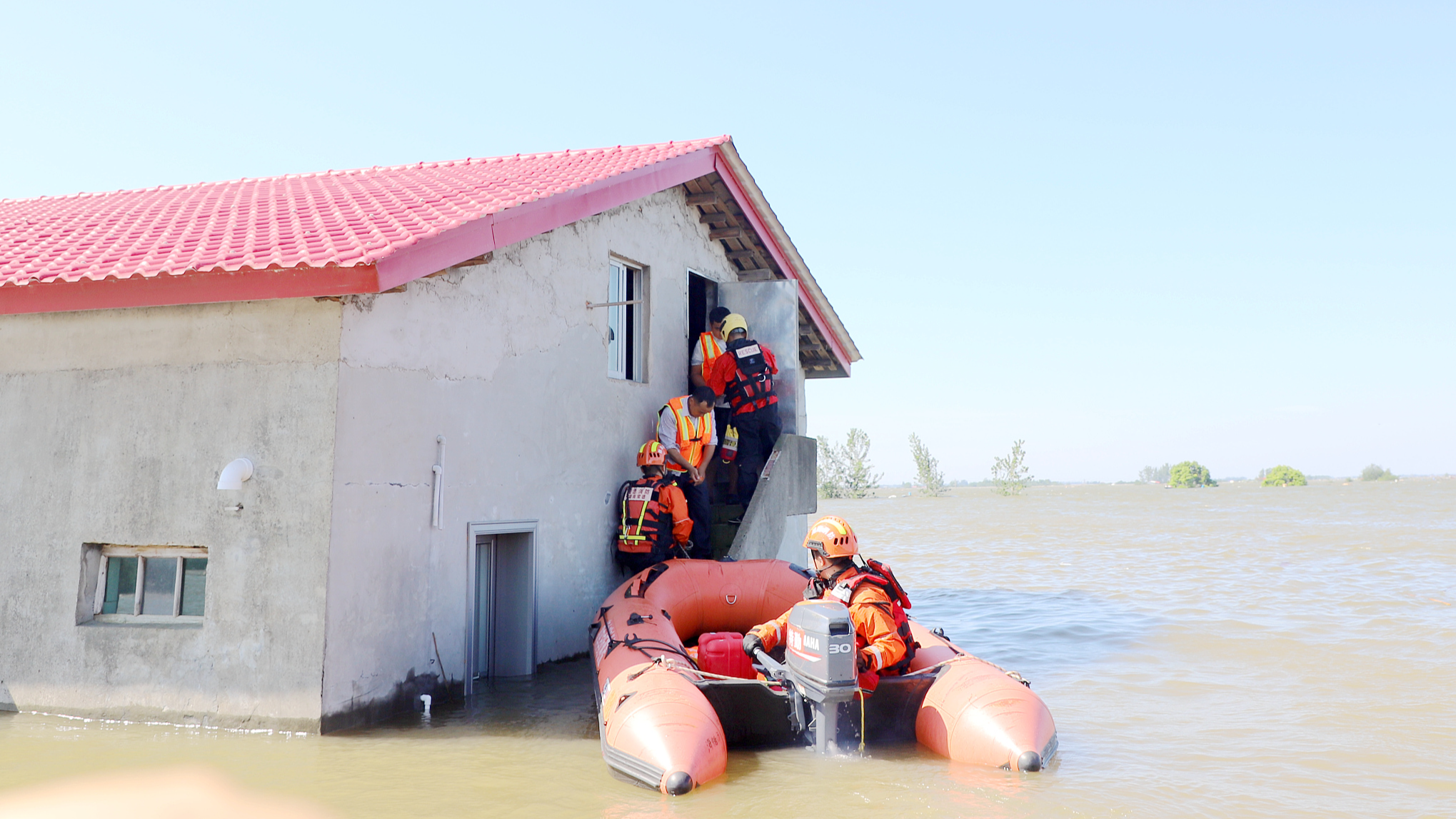 Firefighters rescue people from a house submerged by flood water in Tuanbei Village, Hunan Province, China, July 6, 2024. /CFP
