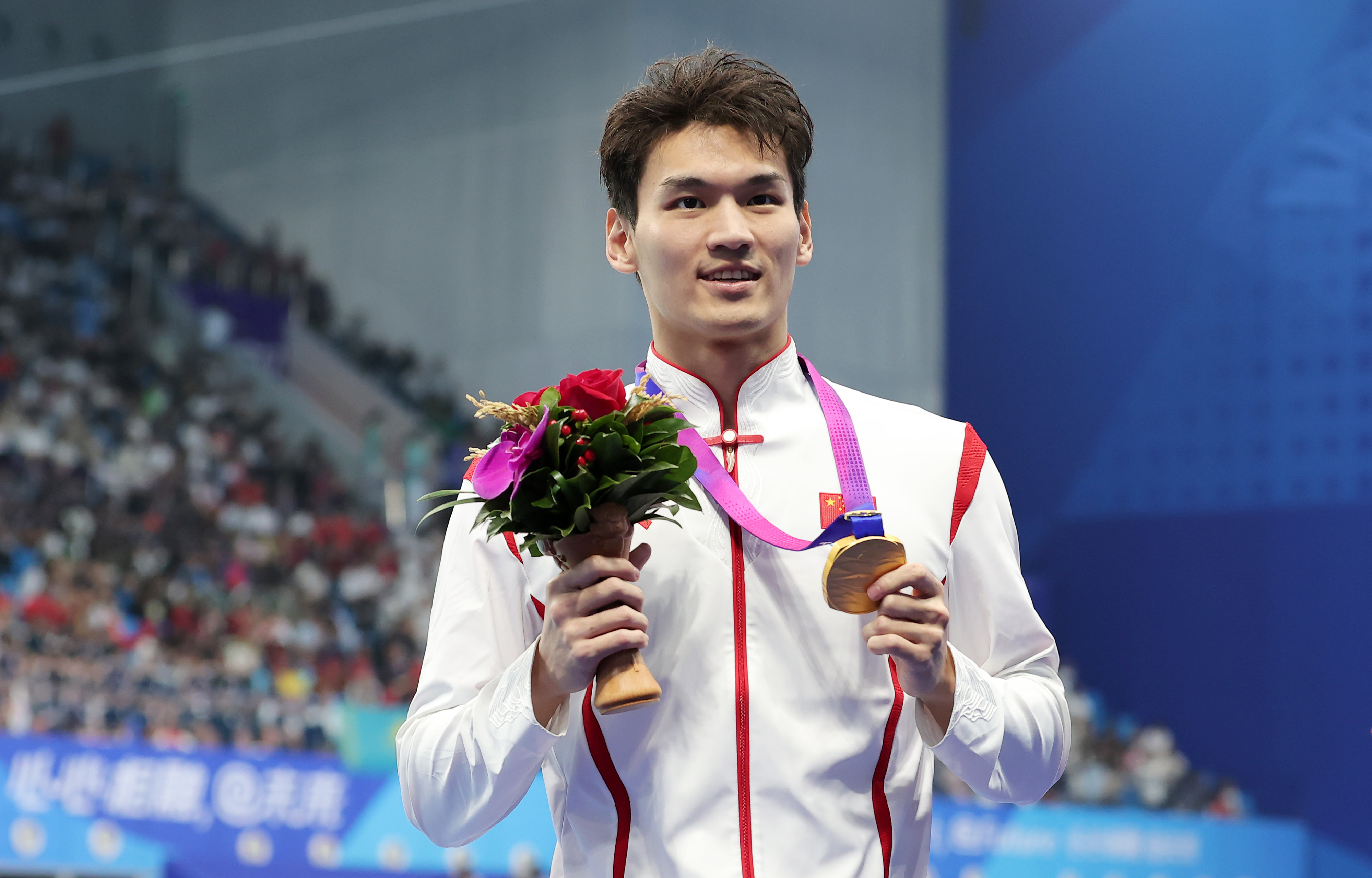 China's Xu Jiayu displays his gold medal after winning the men's 100m backstroke final at the Asian Games in Hangzhou, China, September 25, 2023. /CFP