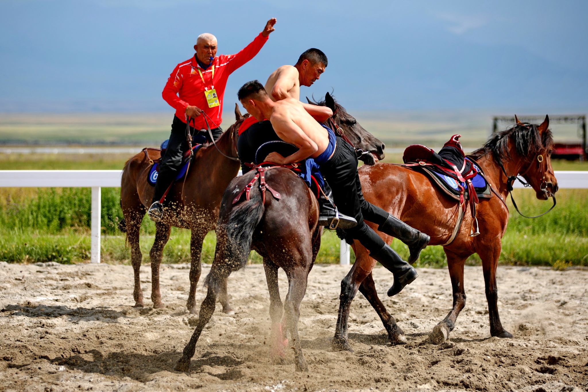 Two men wrestle on horseback during the equestrian events of China's 12th National Traditional Games of Ethnic Minorities held in Xinjiang on July 8, 2024. /CFP