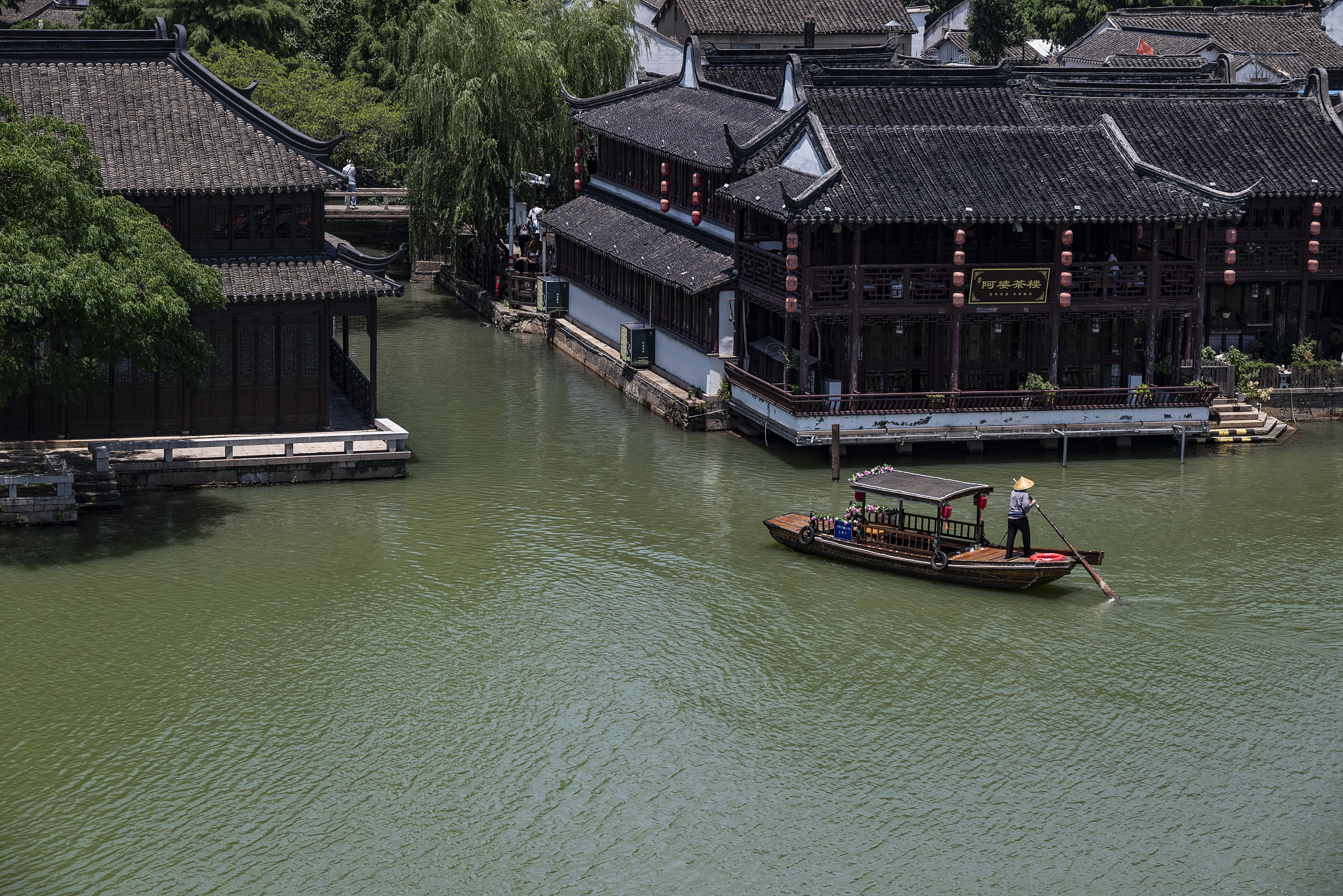 A man paddles a small boat in the waterways of Zhujiajiao Ancient Town in the southwestern suburbs of Shanghai, July 7, 2024. /CFP