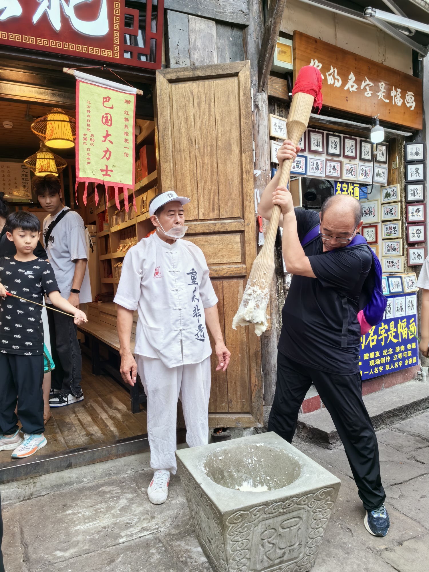 A tourist learns to make traditional glutinous rice cakes in Ciqikou ancient town, Chongqing, on July 10, 2024. /CGTN