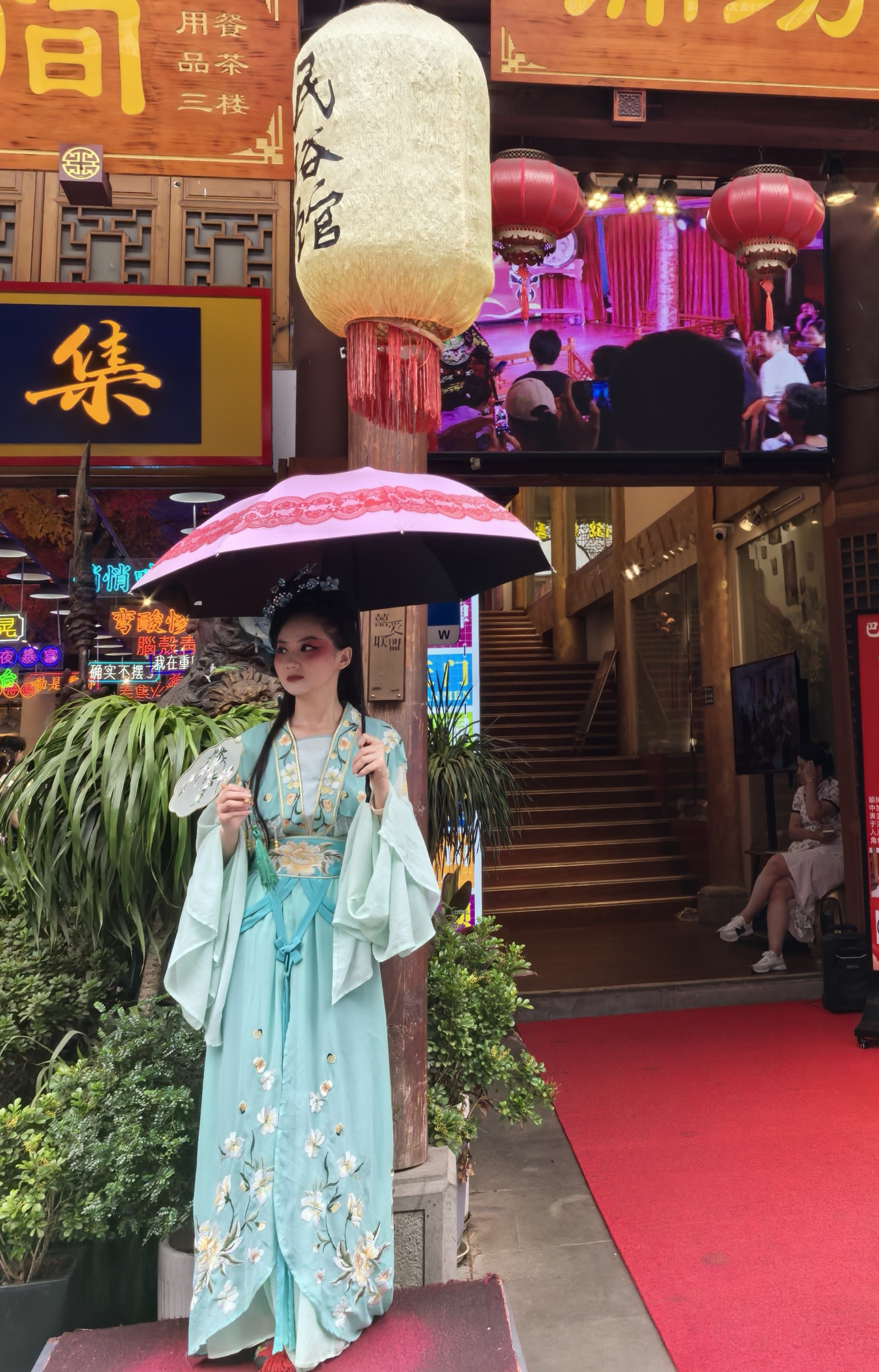 A woman in traditional Chinese attire stands on street to attract customers in Ciqikou ancient town, Chongqing, on July 10, 2024. /CGTN