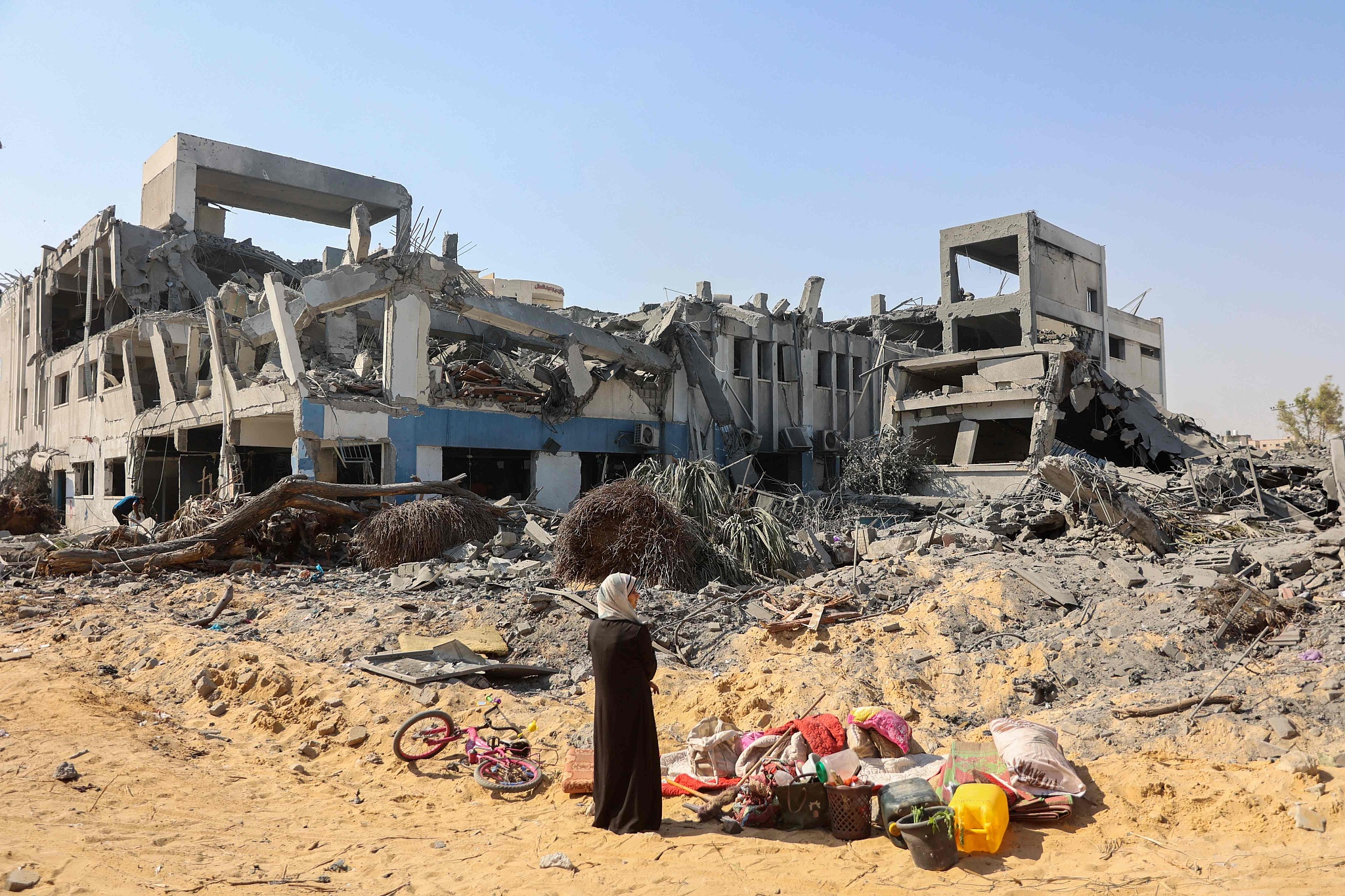 A woman looks around as she salvages items at the damaged UN Relief and Works Agency for Palestine Refugees building complex in western Gaza City's al-Sina'a neighborhood following the withdrawal of Israeli troops from the area, July 12, 2024. /CFP