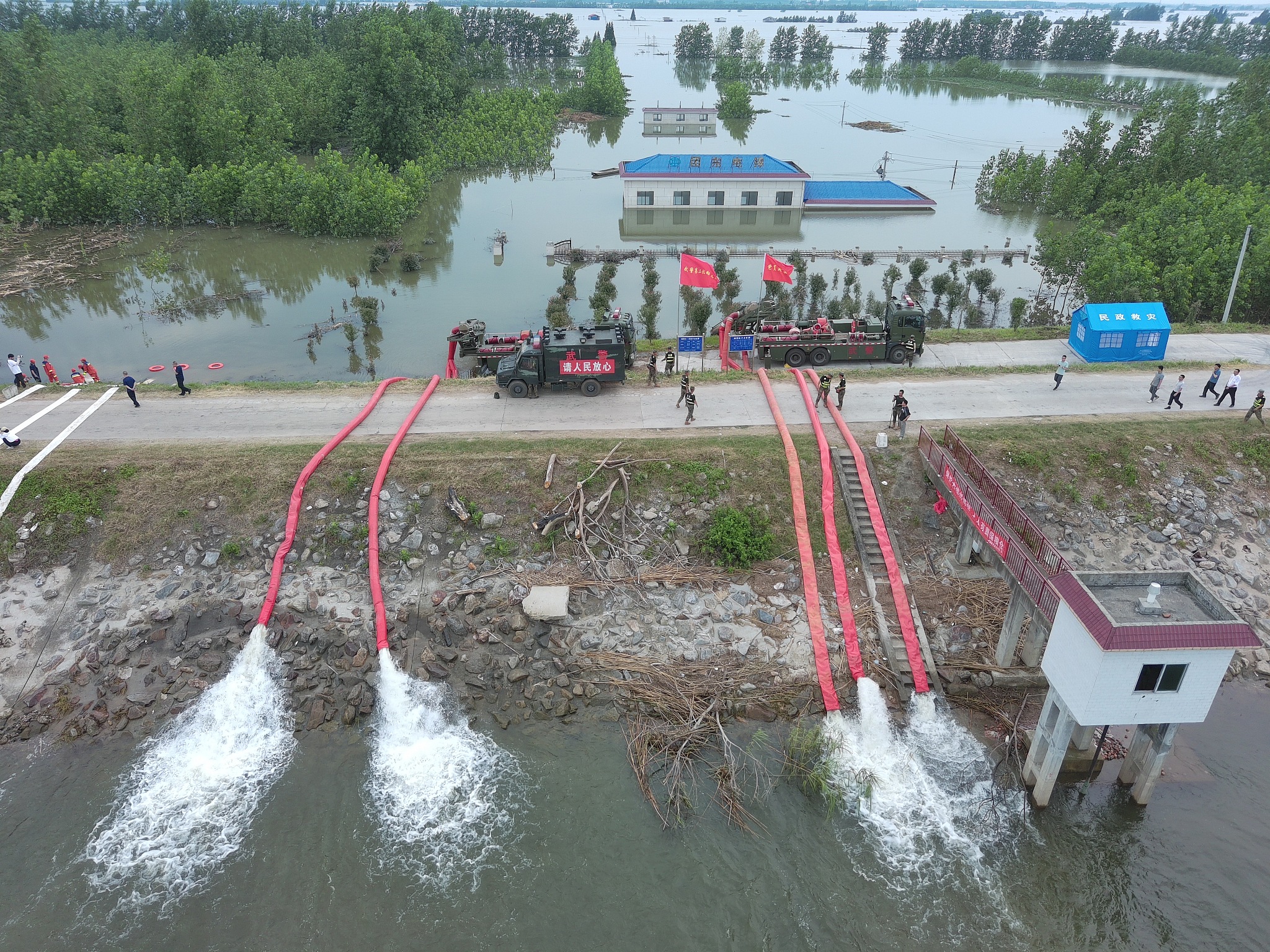 Rescuers work on an embankment to stem the piping effect in Huarong County, central China's Hunan Province, July 10, 2024. /CFP