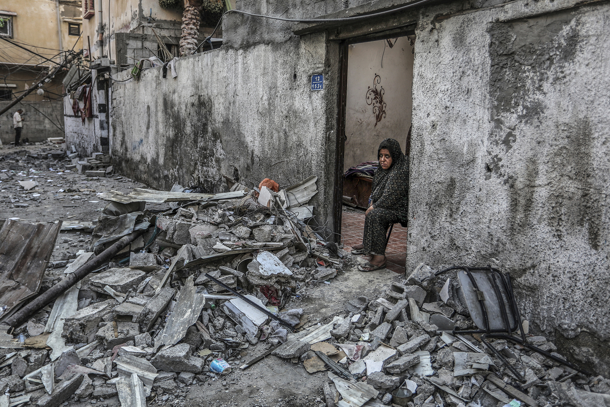 A Palestinian woman looks at a damaged house after a missile attack by Israeli warplanes on a house belonging to the Al-Rai family in Deir Al-Balah, July 13, 2024. /CFP