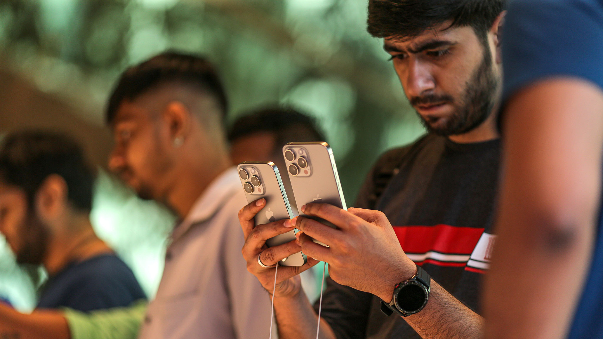 A customer holds iPhone 15 Pro smartphones at an Apple store during the device's first day of sale, Mumbai, India, September 22, 2023. /CFP