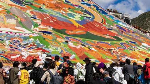 A huge thangka painting is unrolled during the 