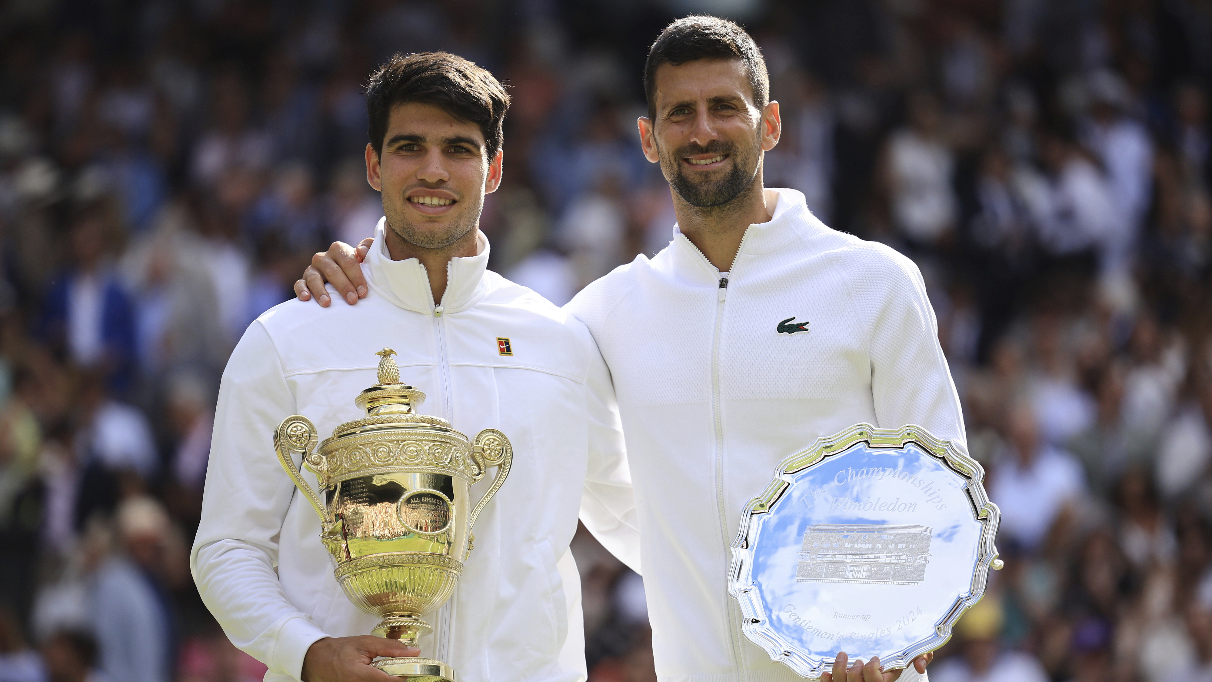 Carlos Alcaraz of Spain (L) and Novak Djokovic of Serbia pose with their trophies after the men's singles final at the Wimbledon Championships in London, United Kingdom, July 14, 2024. /CFP