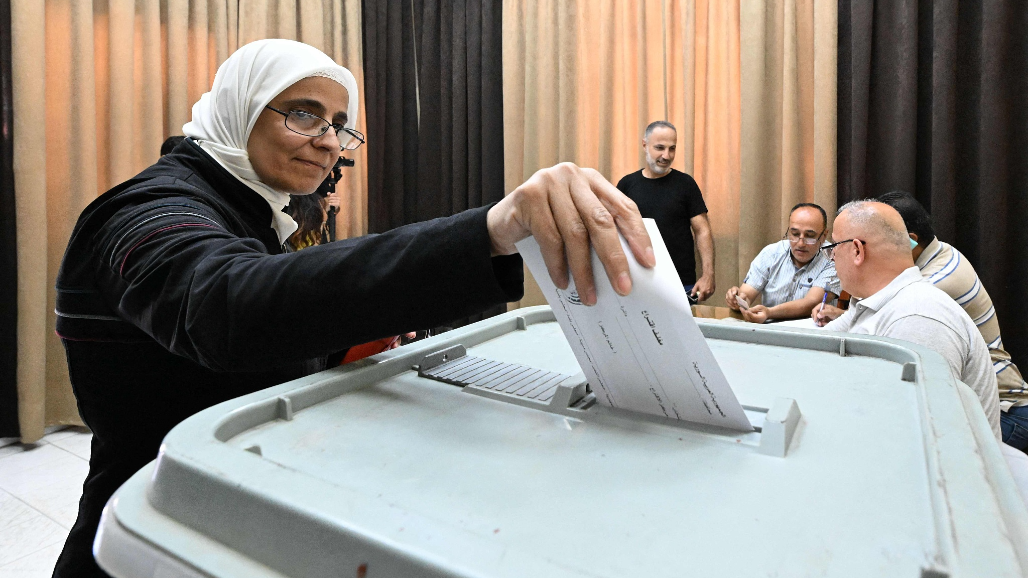 A woman casts her ballot as Syrians elect new members of the Parliament at a polling station in Damascus on July 15, 2024. /CFP