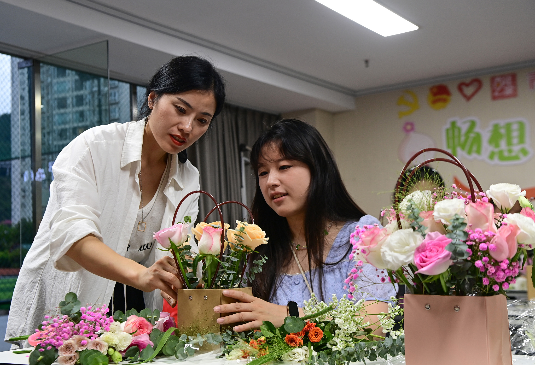 Students enrolled in a night school course receive a flower arrangement tutorial in Chongqing, June 18, 2024. /CFP
