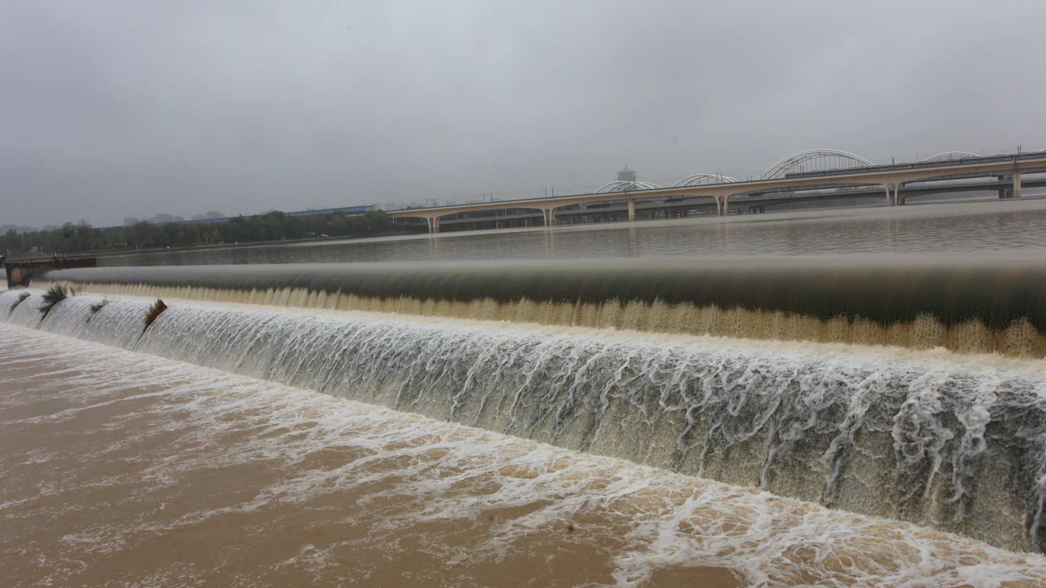 After continuous rainfall, water overflows from the Bahe River dam in Xi'an, Shaanxi Province, China, July 9, 2024. /CFP