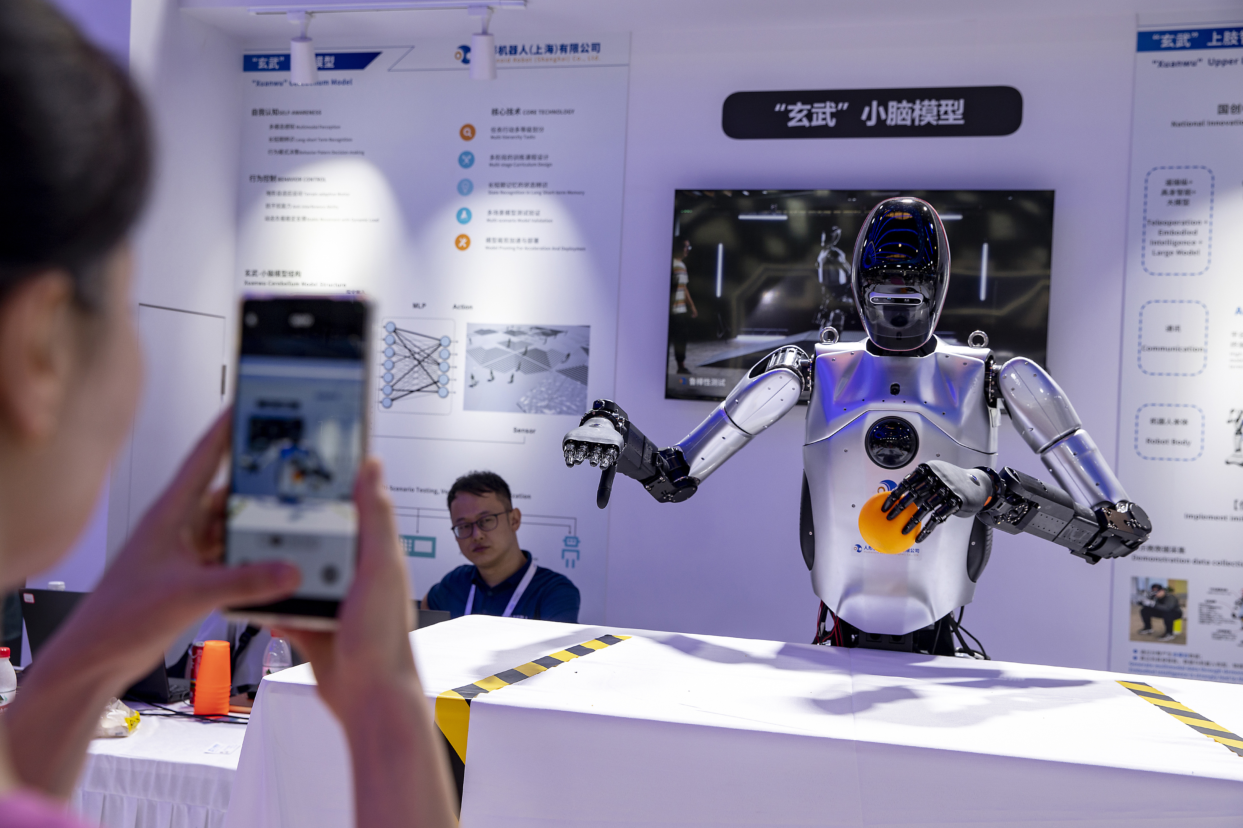 A visitor takes a photo of a humanoid robot at the 2024 World Artificial Intelligence Conference, Shanghai, China, July 6, 2024. /CFP