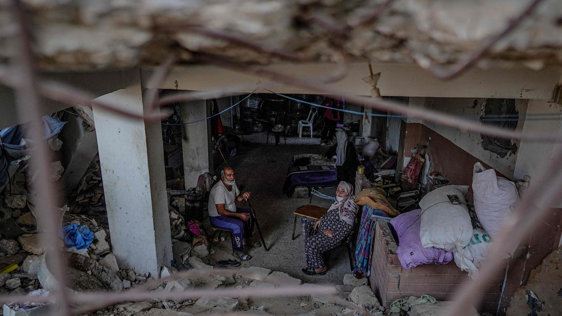 Palestinians sits inside a house that was heavily damaged by Israeli bombardment, in the town of Bani Suheila near Khan Younis in the southern Gaza Strip, July 17, 2024. /CFP