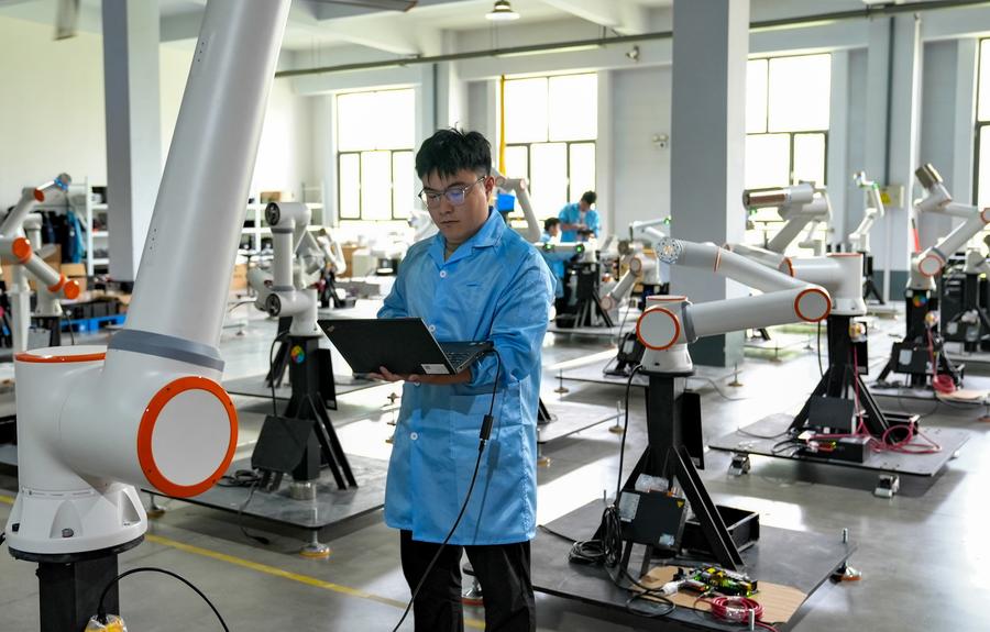 A technician adjusts robots at a workshop in Zibo City, east China's Shandong Province, May 12, 2024. /Xinhua