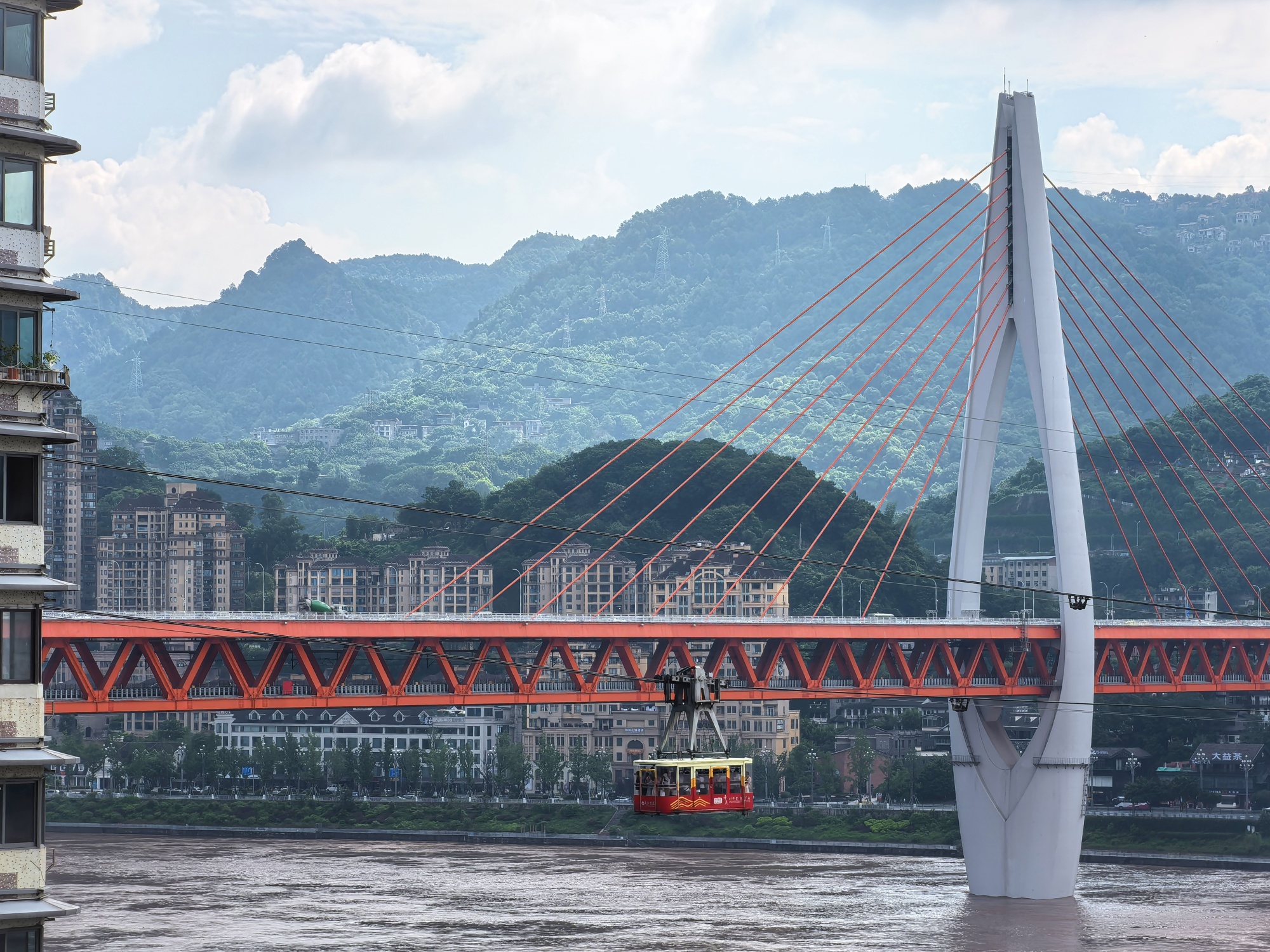 A cable car runs above the Yangtze River in Chongqing on July 12, 2024. /CGTN