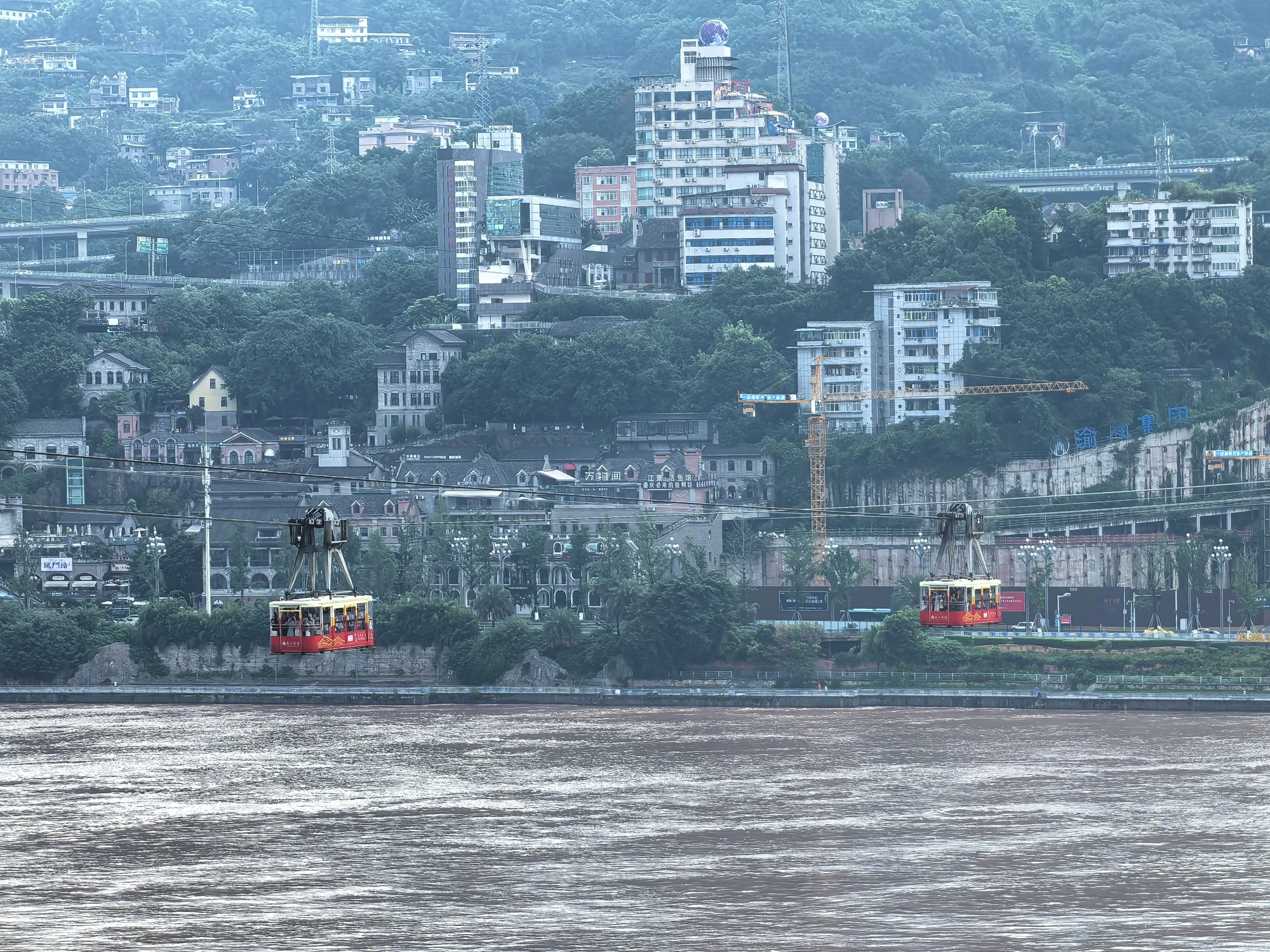 Two cable cars run above the Yangtze River in Chongqing on July 12, 2024. /CGTN