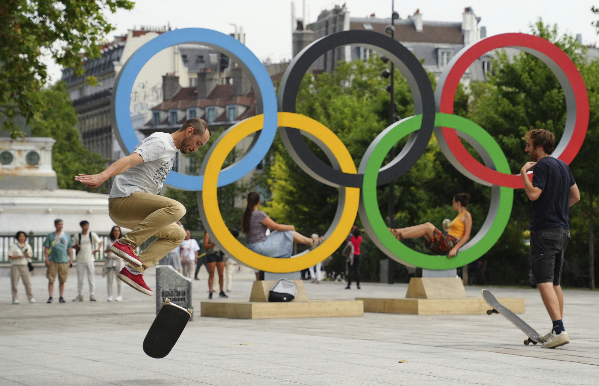 Skateboarders perform in front of the Olympic Rings at Place de la Bastille, Paris, France, July 19, 2024. /CFP