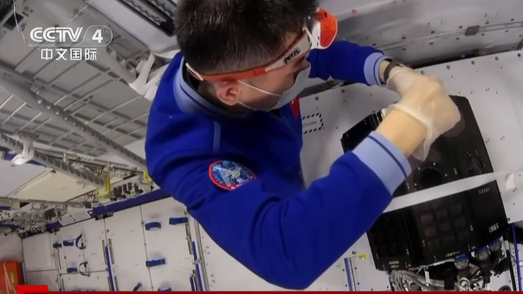 A Shenzhou-18 crew member carries out an experimental sample replacement. /CMG