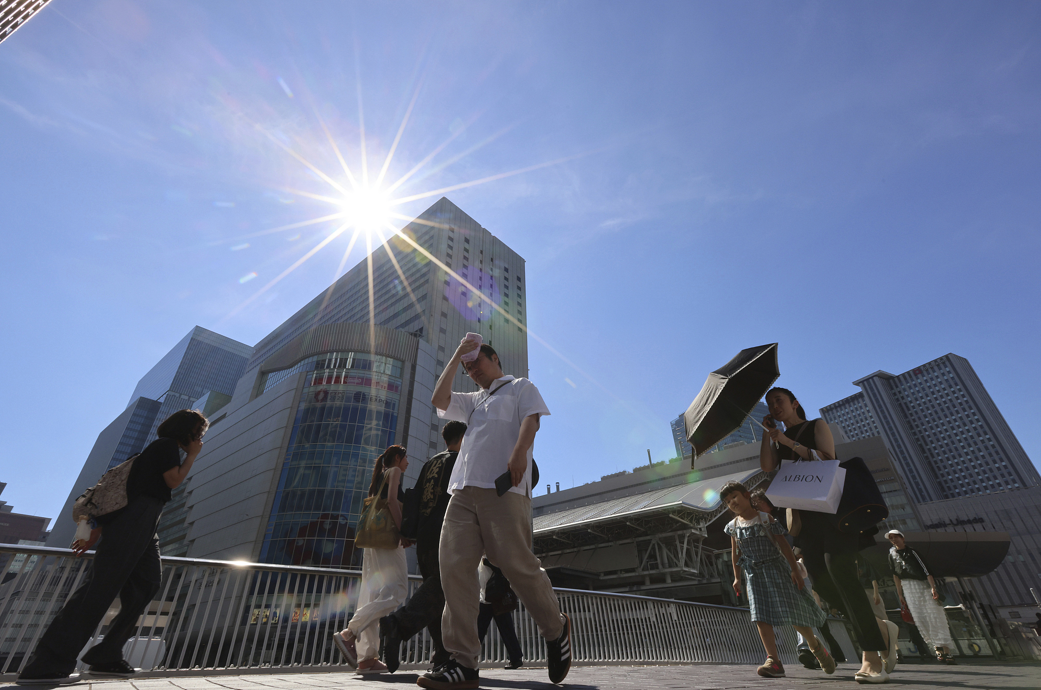 Pedestrians walk under a strong sunshine in Japan's Osaka Prefecture on July 21, 2024. /CFP