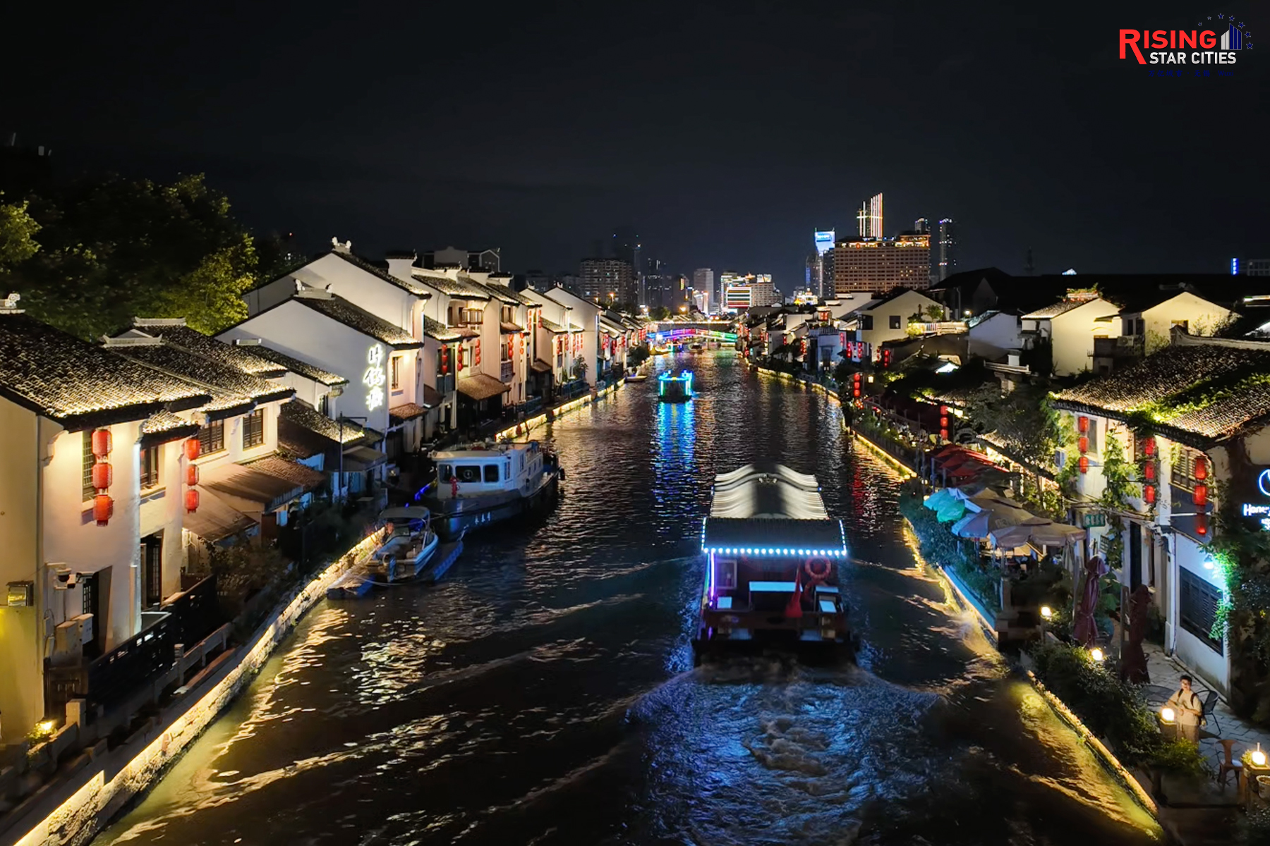 A photo taken on July 21, 2024 shows the traditional Chinese architecture lining the waterway near the Qingming Bridge lit up at night in Wuxi, Jiangsu Province. CGTN