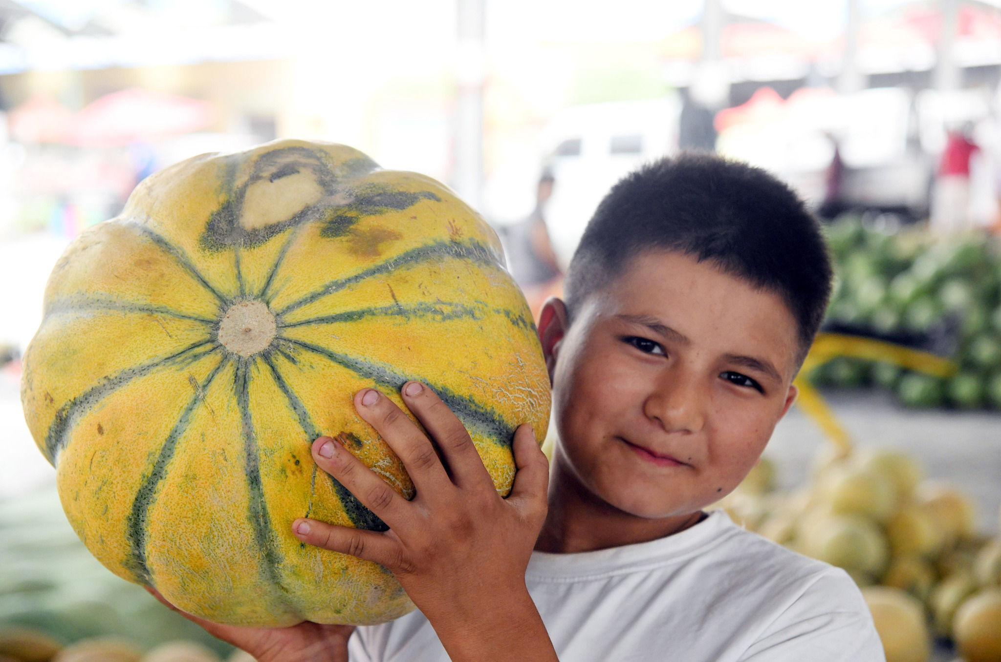 A boy holds a giant melon at a wholesale market in Kashgar, northwest China's Xinjiang Uygur Autonomous Region. /CFP
