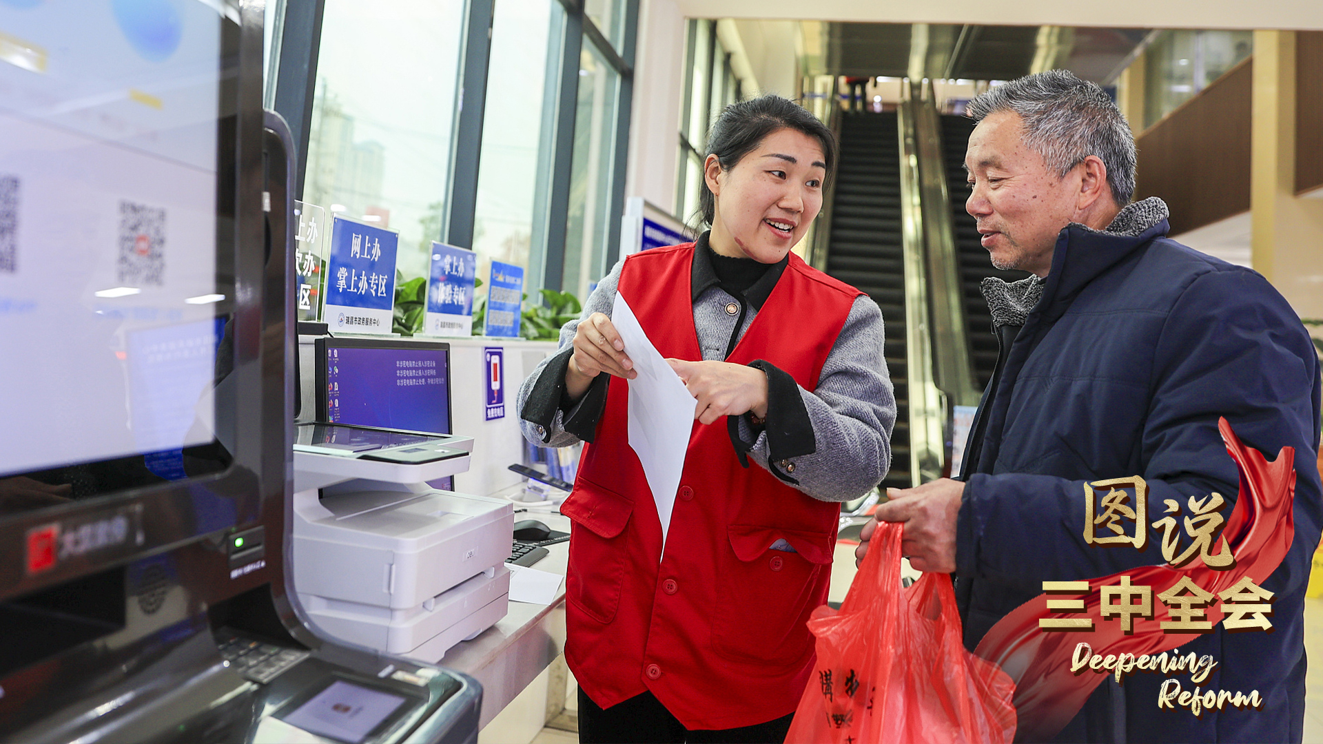 A volunteer explains the old-age insurance process to an elderly man in a hall at the government affairs service center in Ruichang City, east China's Jiangxi Province, March 7, 2024. /CFP
