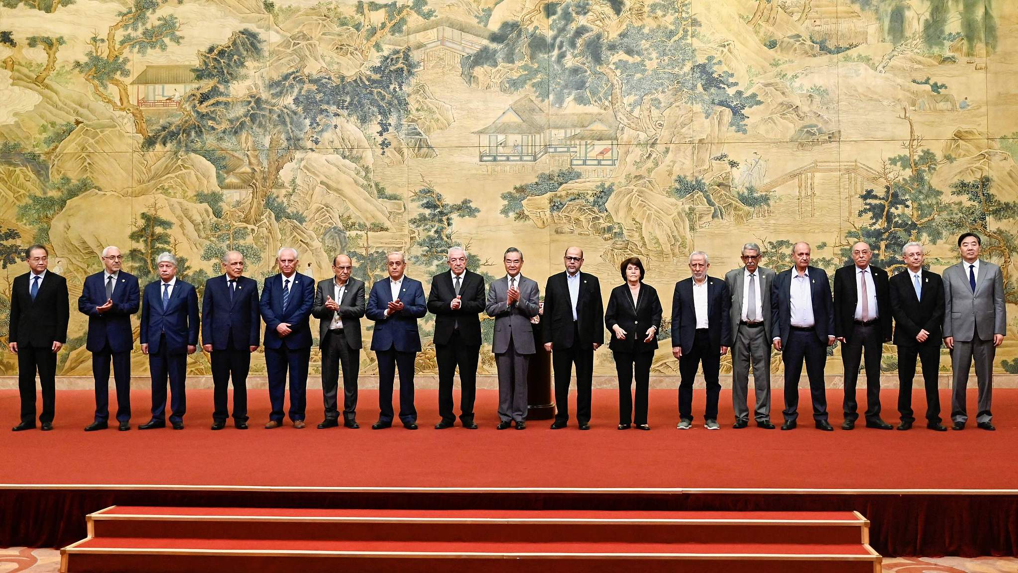 Chinese Foreign Minister Wang Yi (C) along with representatives of 14 Palestinian factions attend the closing ceremony of the reconciliation talks of Palestinian factions in Beijing, China, July 23, 2024. /CFP