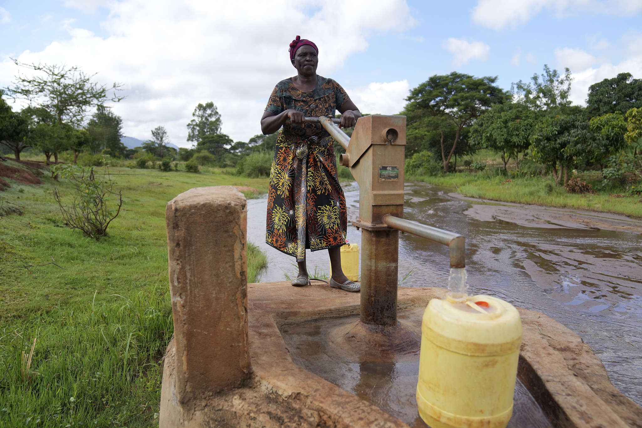 Rhoda Peter fills containers with water from a sand dam in Makueni County, Kenya, March 1, 2024. /CFP