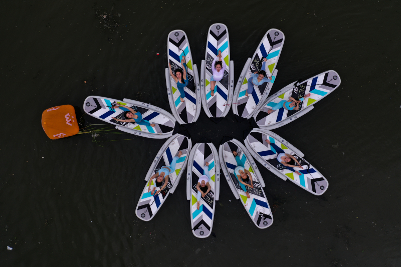 Yoga teachers are seen in an aerial photo demonstrating paddleboard yoga on the Hunhe River in Shenyang, Liaoning Province on July 24, 2024. /CFP