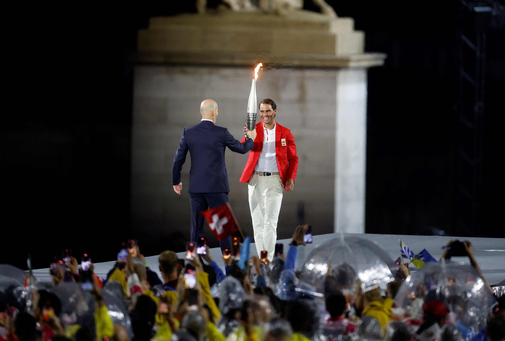 French football legend Zinedine Zidane (L) hands over the Olympic Torch to Spanish tennis superstar Rafael Nadal at the Opening Ceremony of the 2024 Summer Olympics in Paris, France, July 26, 2024. /CFP