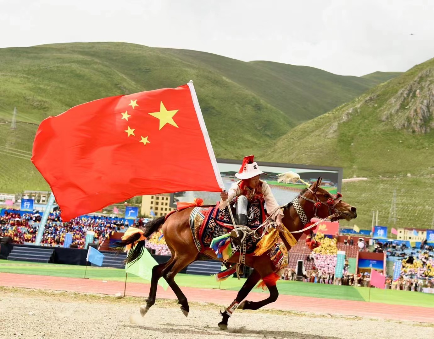 A boy holds a Chinese national flag while riding at the opening of the Yushu Horse Racing Festival in Yushu City, Yushu Tibetan Autonomous Prefecture, northwest China's Qinghai Province, July 25, 2024. /Courtesy of Publicity Department of the CPC Yushu Municipal Committee