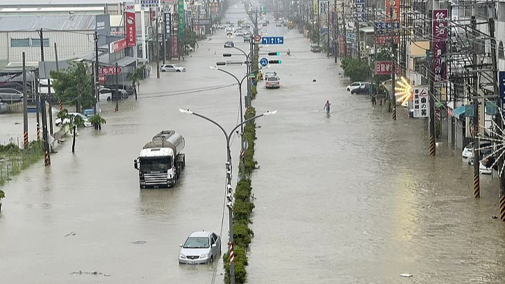 People and vehicles wade through water along a street that was flooded by Typhoon Gaemi in Kaohsiung, Taiwan, China, July 25, 2024. /CFP