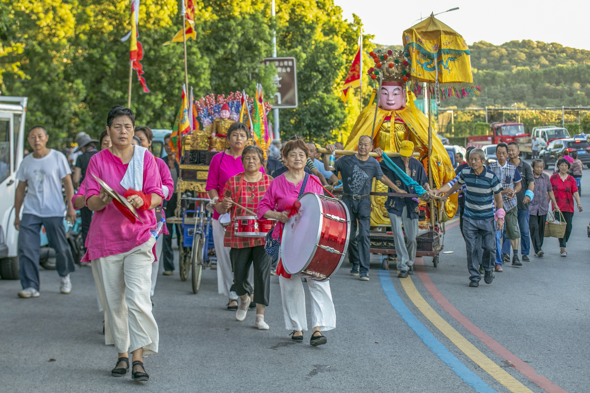 Residents carry large flags and beat drums as they parade with the statue of the Valiant General at the Lotus Festival in Suzhou, Jiangsu Province on July 29, 2024. /CFP