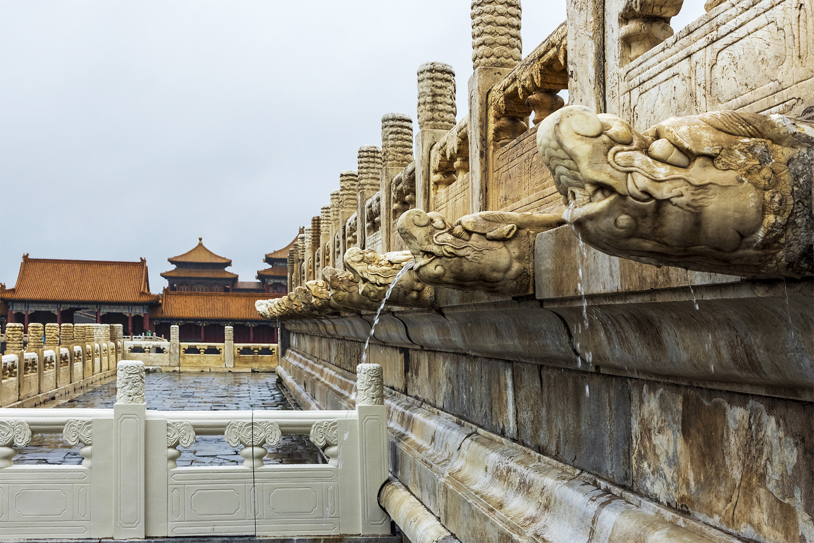 Rainwater spouts from the mouths of stone dragon heads at the Palace Museum in Beijing during a heavy rain on July 30, 2024. /CFP