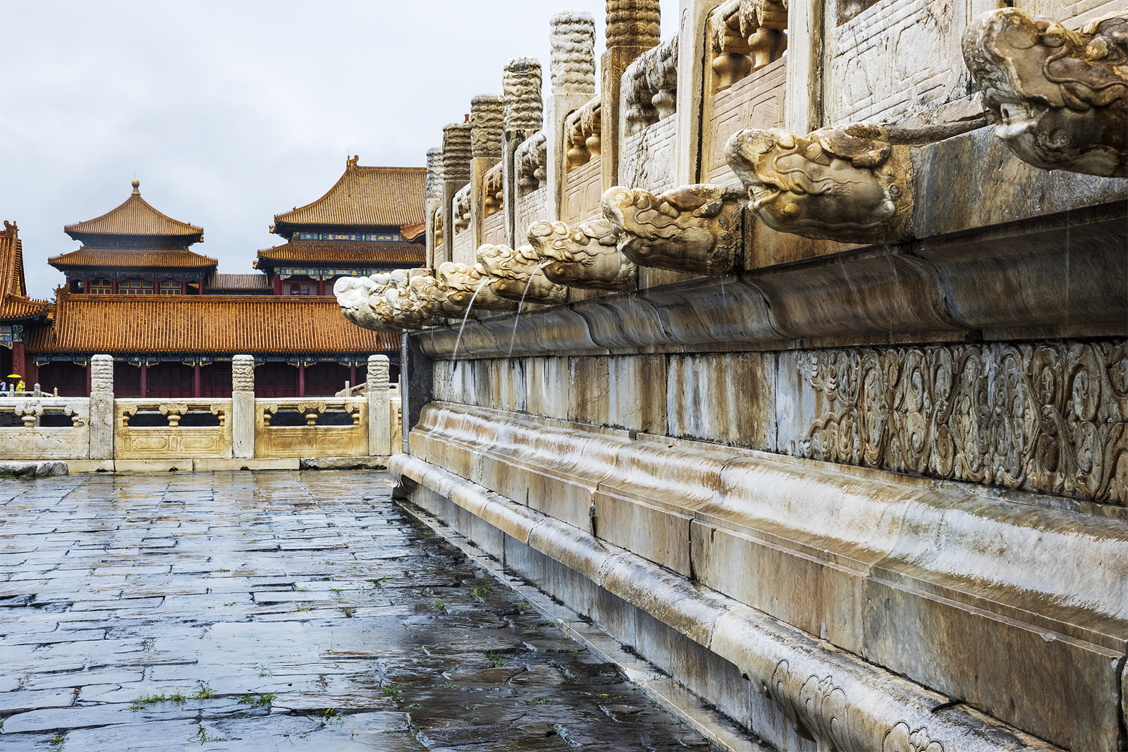 Rainwater spouts from the mouths of stone dragon heads at the Palace Museum in Beijing during a heavy rain on July 30, 2024. /CFP