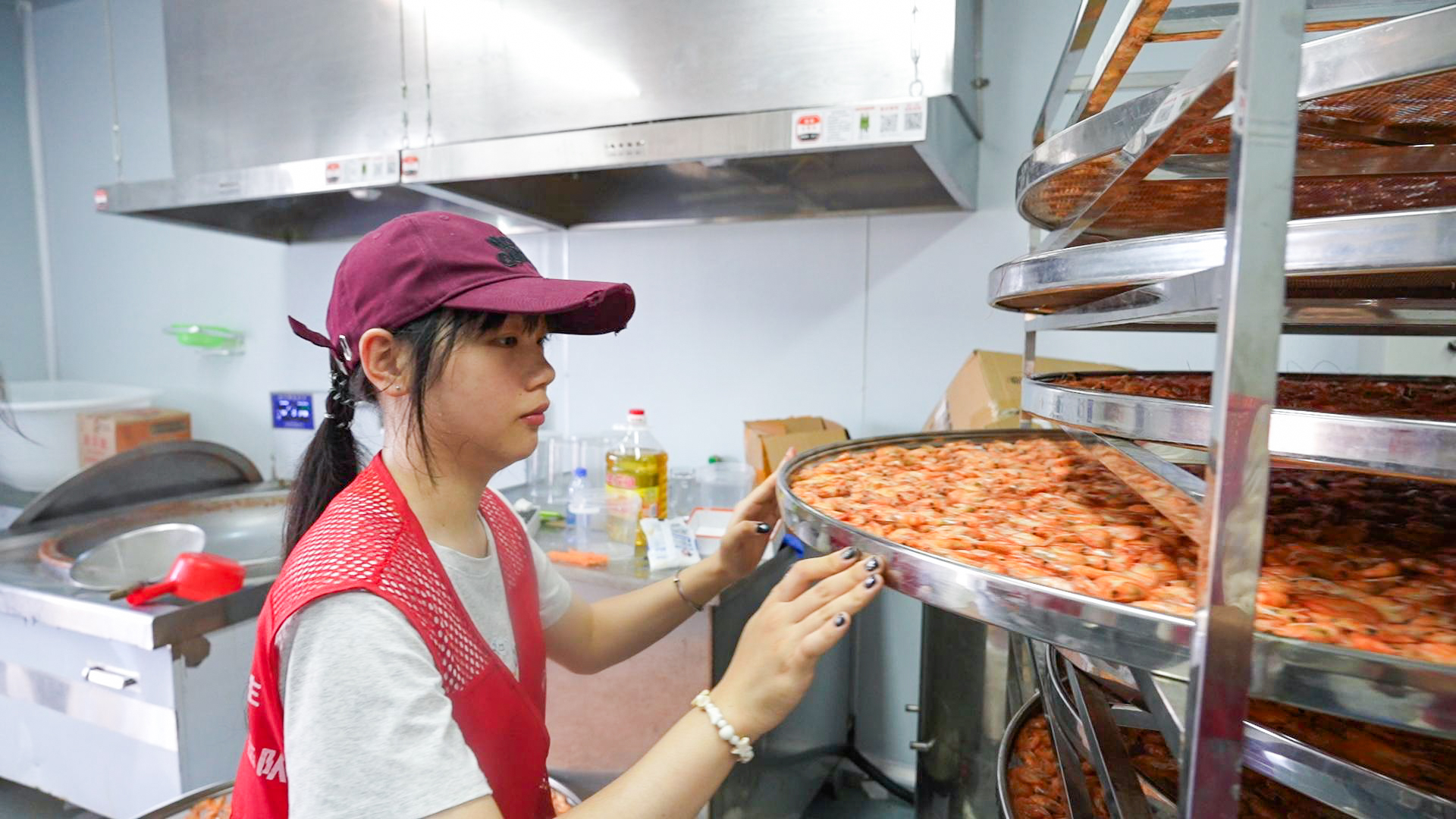 A student helps villagers cook shrimps before package them for sales in Huilai. 