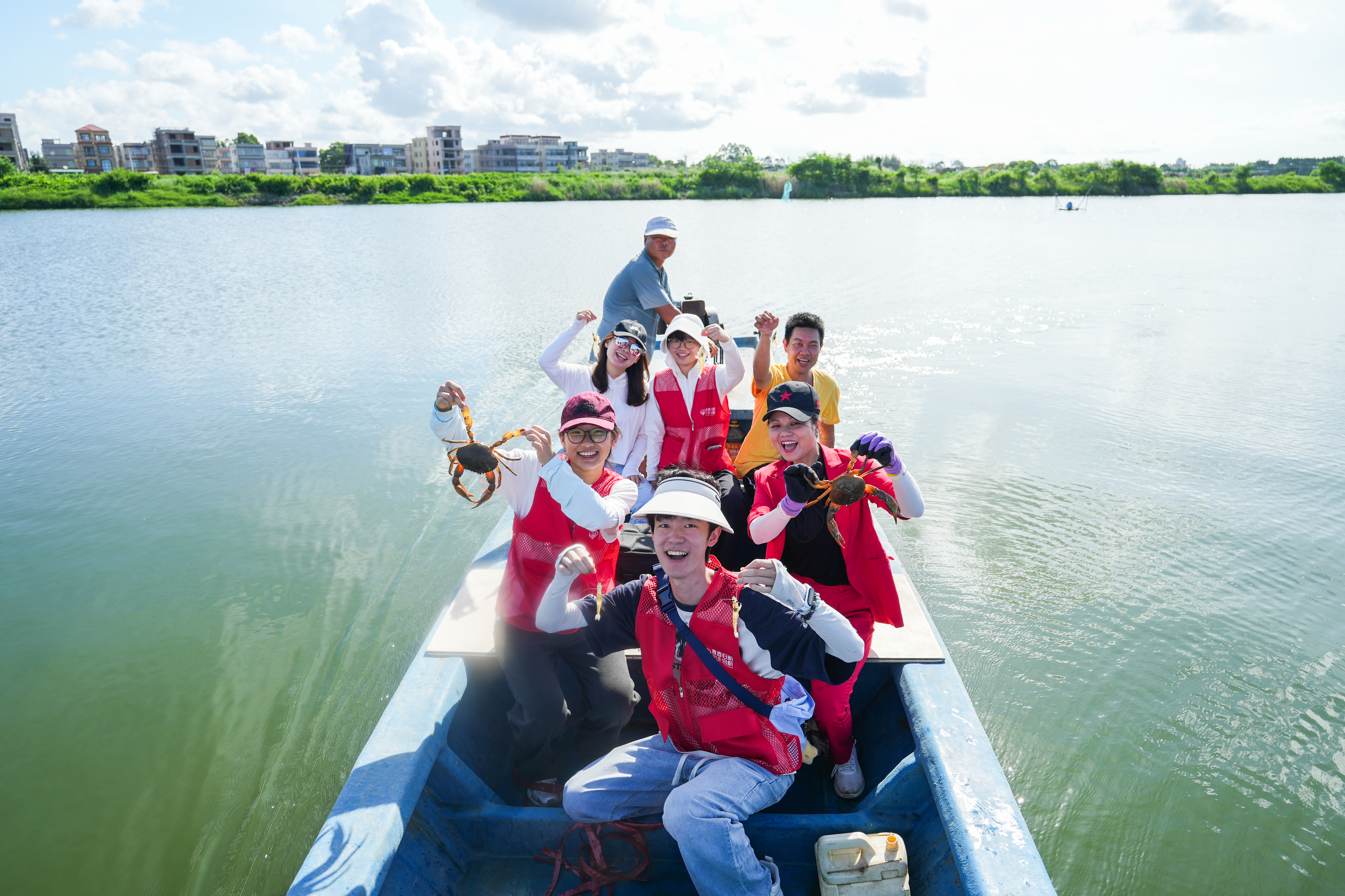 Students from Guangdong Food and Drug Vocational College show their harvest from a lake in Huilai County, Guangdong Province. 