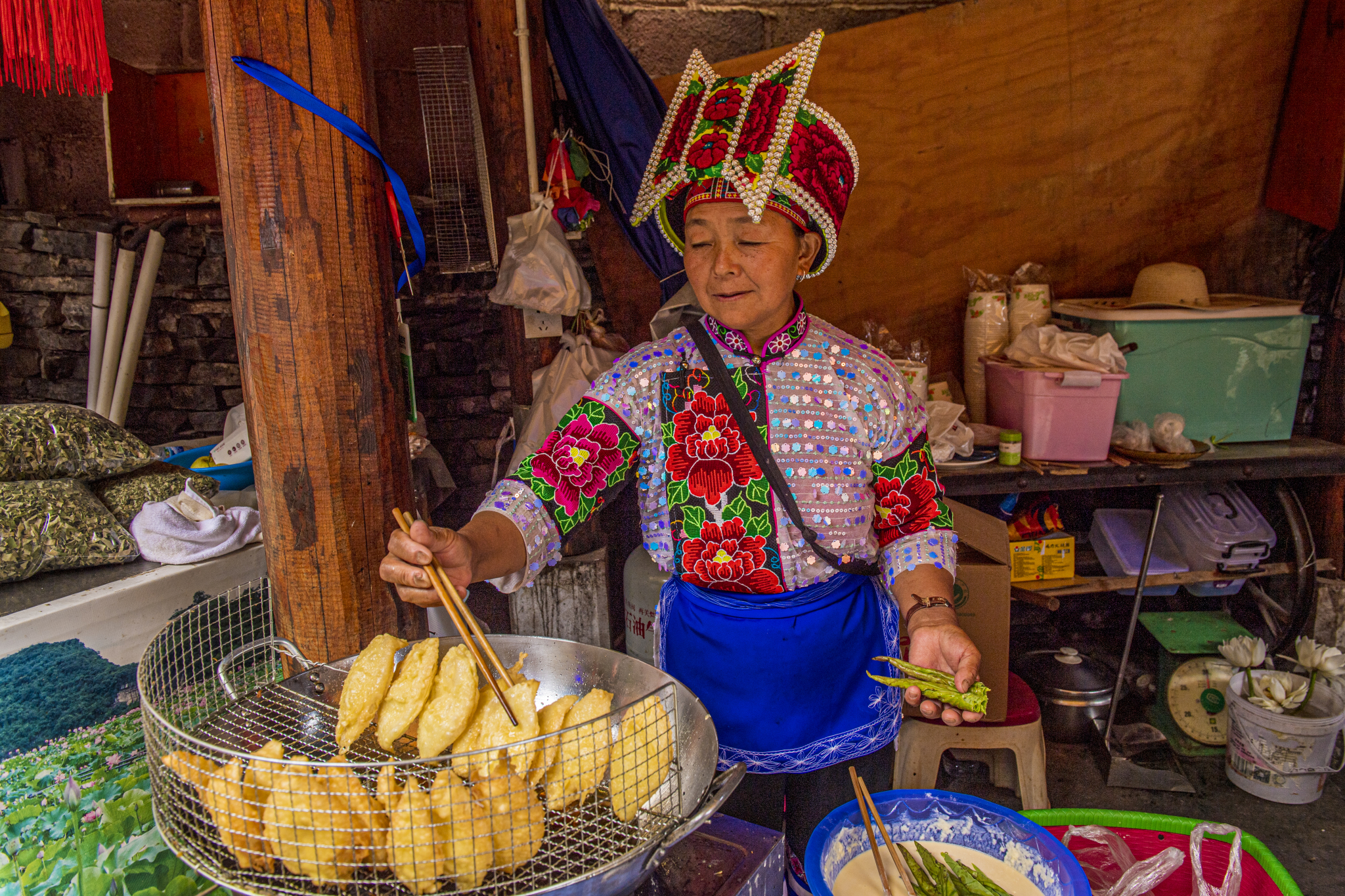 An elderly woman is seen making snacks in Xianrendong Village, Yunnan Province on July 6, 2024. /CFP 