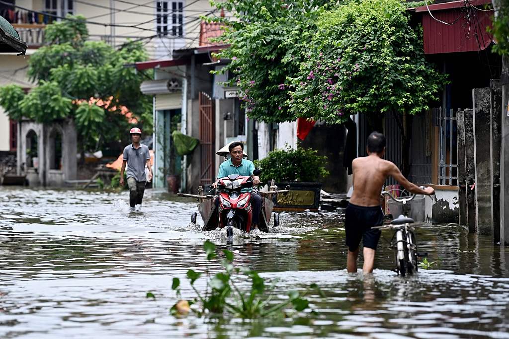 A man rides a scooter through flood waters in Ben Voi village on the outskirts of Hanoi, Vietnam, July 29, 2024. /CFP