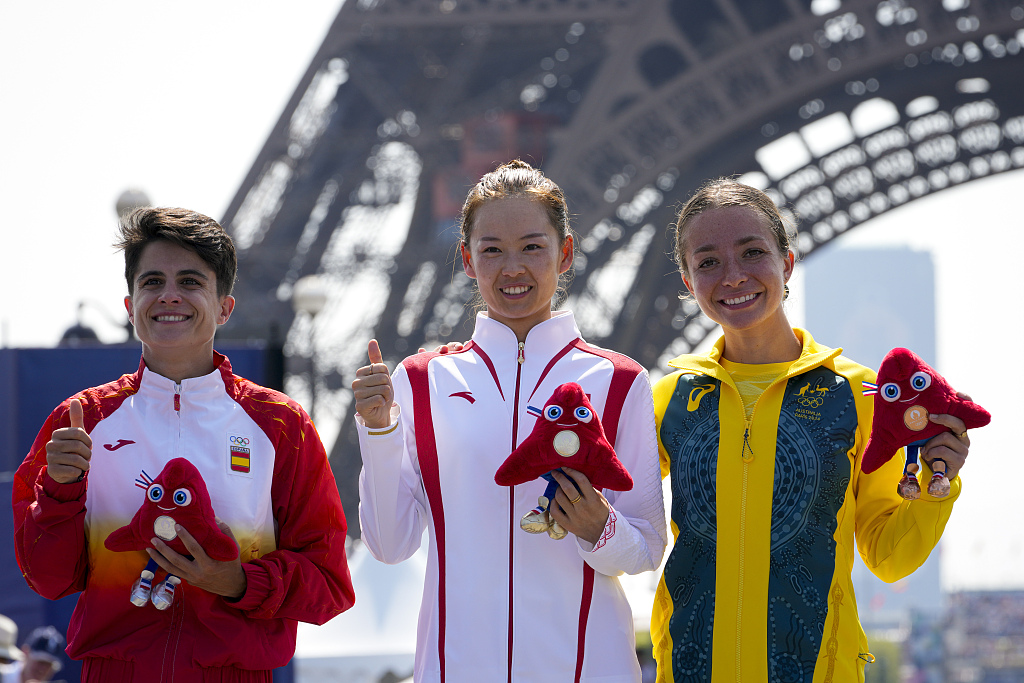 Gold medalist Yang Jiayu (C) of China, silver medalist Maria Perez (L) of Spain and bronze medalist Jemima Montag of Australia celebrate on the podium in front of the Eiffel Tower after their women's 20m race walk final at the Summer Olympics in Paris, France, August 1, 2024. /CFP