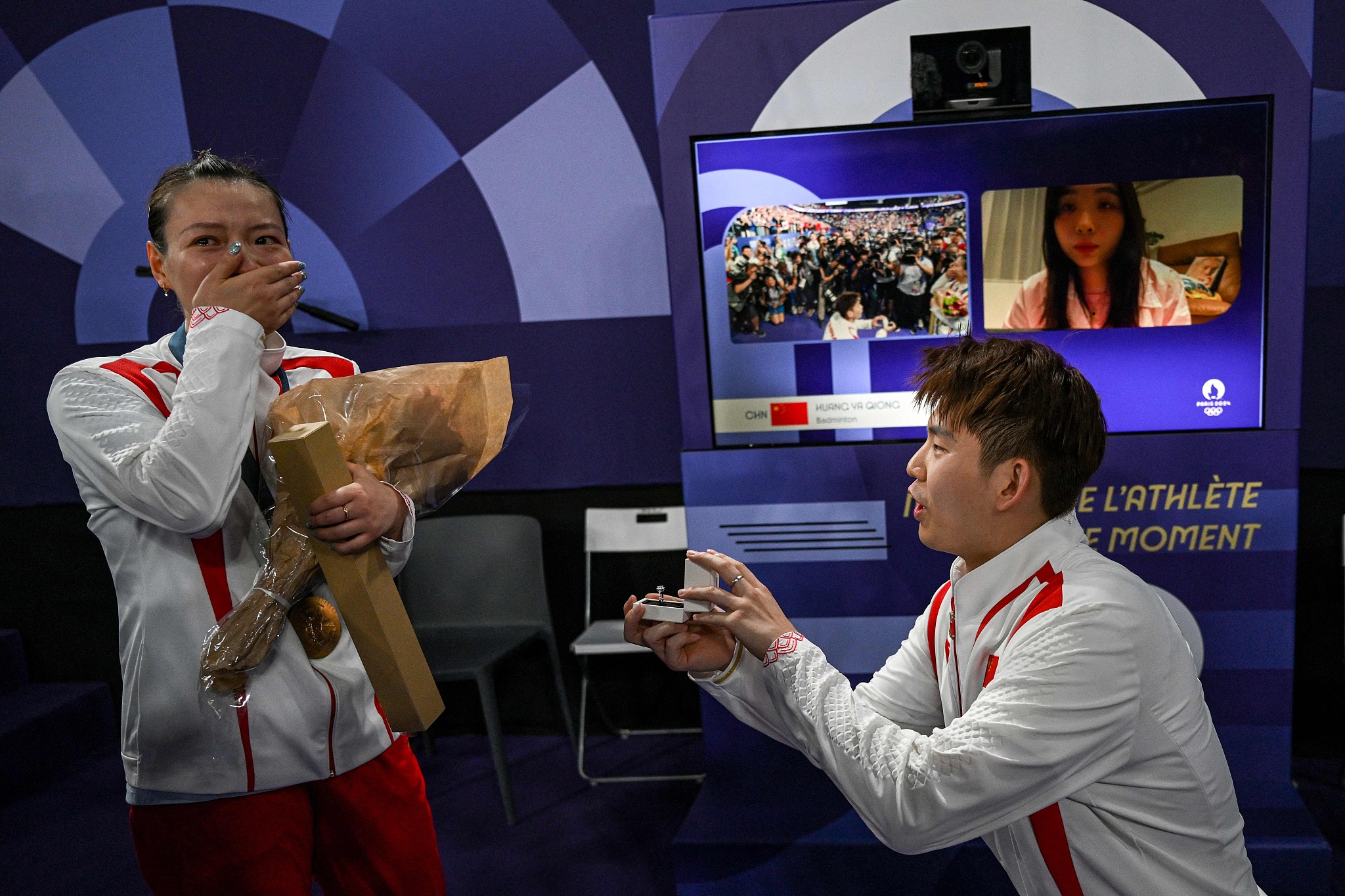 Liu Yuchen (R) of China proposes to Huang Yaqiong after the mixed doubles badminton final at the 2024 Summer Olympics in Paris, France, August 2, 2024. /CFP