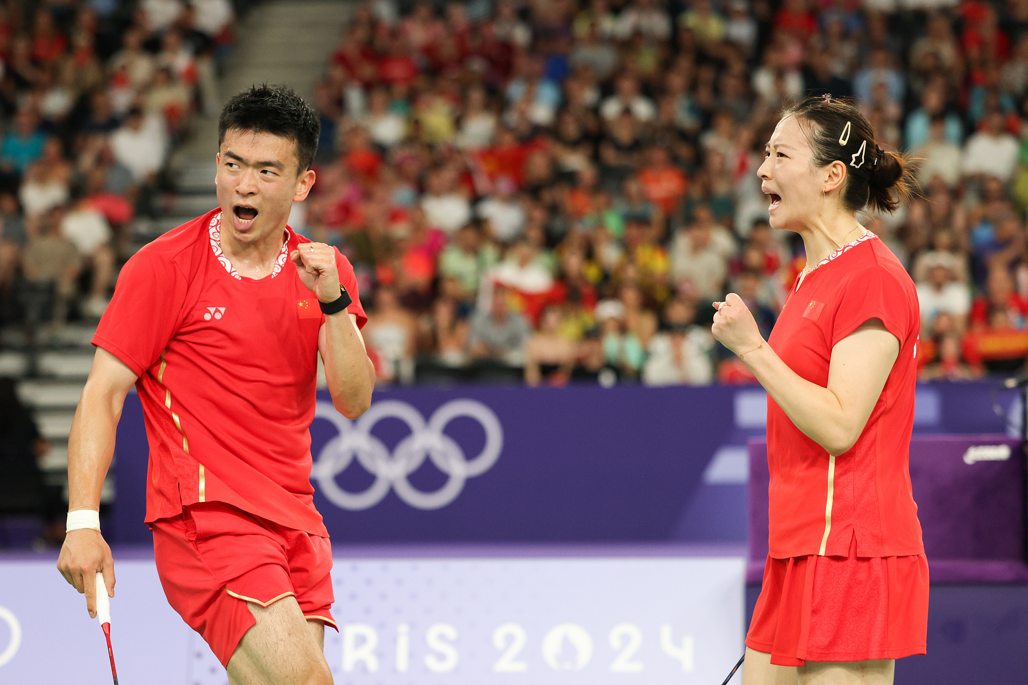 Zheng Siwei (L) and Huang Yaqiong of China react after scoring a point in the mixed doubles badminton final against Kim Won-ho and Jeong Na-eun of South Korea at the 2024 Summer Olympics in Paris, France, August 2, 2024. /CFP