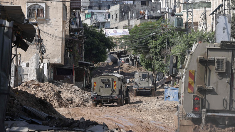Israeli military vehicles drive through a road dug up by the army during a raid in the Tulkarm camp for Palestinian refugees in the occupied West Bank, July 23, 2024. /CFP