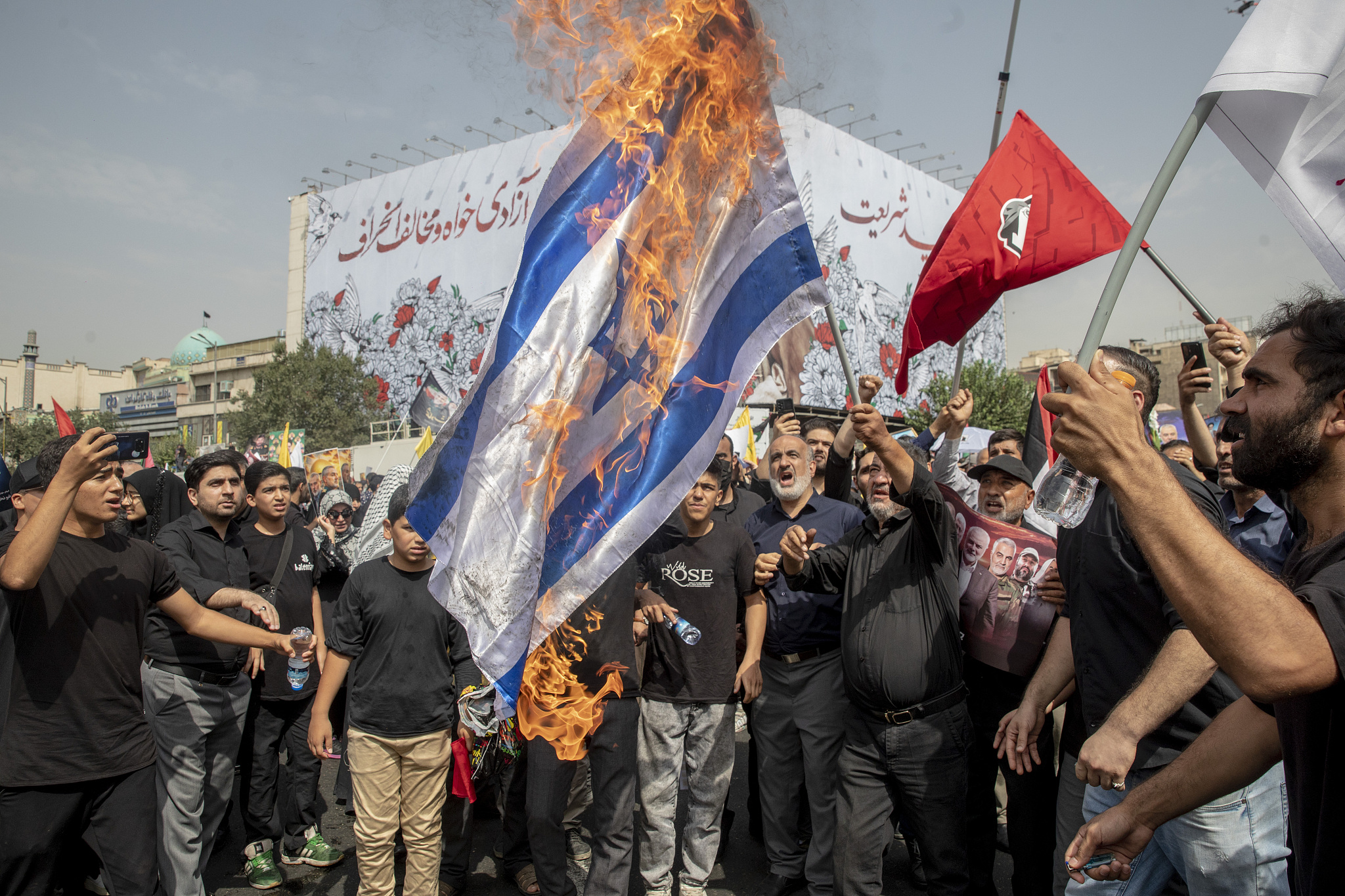 Iranians burn a representation of the Israeli flag during the funeral ceremony of Hamas leader Ismail Haniyeh and his bodyguard, who were killed in an assassination blamed on Israel, at Enqelab-e-Eslami (Islamic Revolution) Sq. in Tehran, Iran, August 1, 2024. /CFP