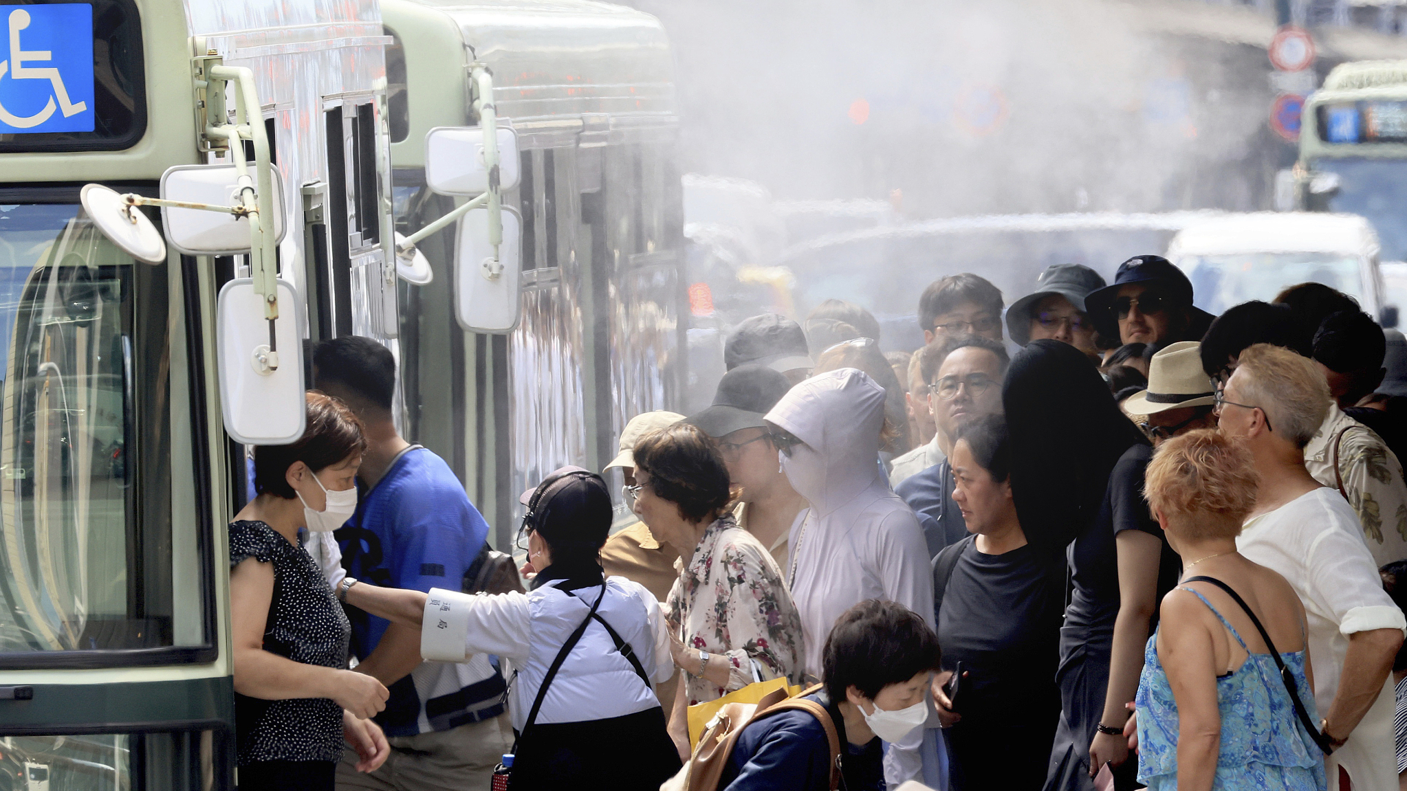 Penumpang berjalan melewati sistem pendingin kabut sebelum menaiki bus di Distrik Shimogyo, Prefektur Kyoto, Jepang bagian barat, 2 Agustus 2024. /CFP