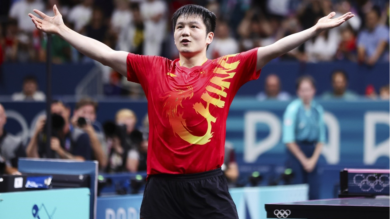 China's Fan Zhendong streches out his arms, imitating the iconic goal celebration of football star Jude Bellingham, after winning the men's singles table tennis final at the 2024 Summer Olympics at South Paris Arena 4 in Paris, France, August 4, 2024. /CFP