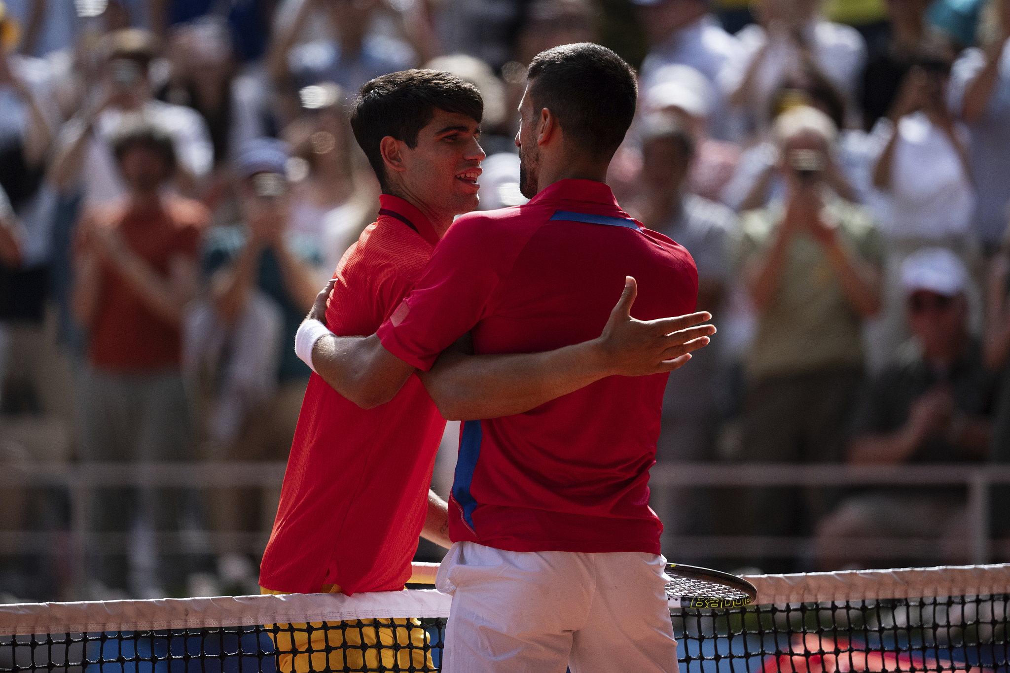 Serbia's Novak Djokovic and Spain's Carlos Alcaraz embrace at the net after the men's singles tennis final at the 2024 Summer Olympics at the Roland Garros Stadium in Paris, France, August 4, 2024. /CFP