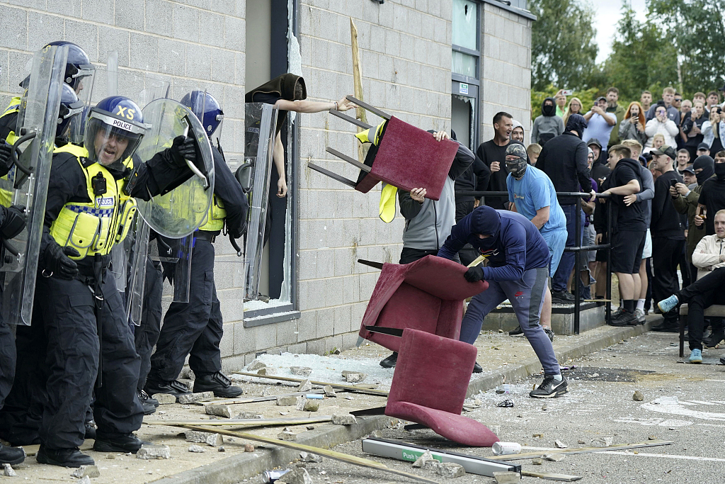 Protesters throw chairs at police officers during an anti-immigration protest outside the Holiday Inn Express in Rotherham, England, August 4, 2024. /CFP