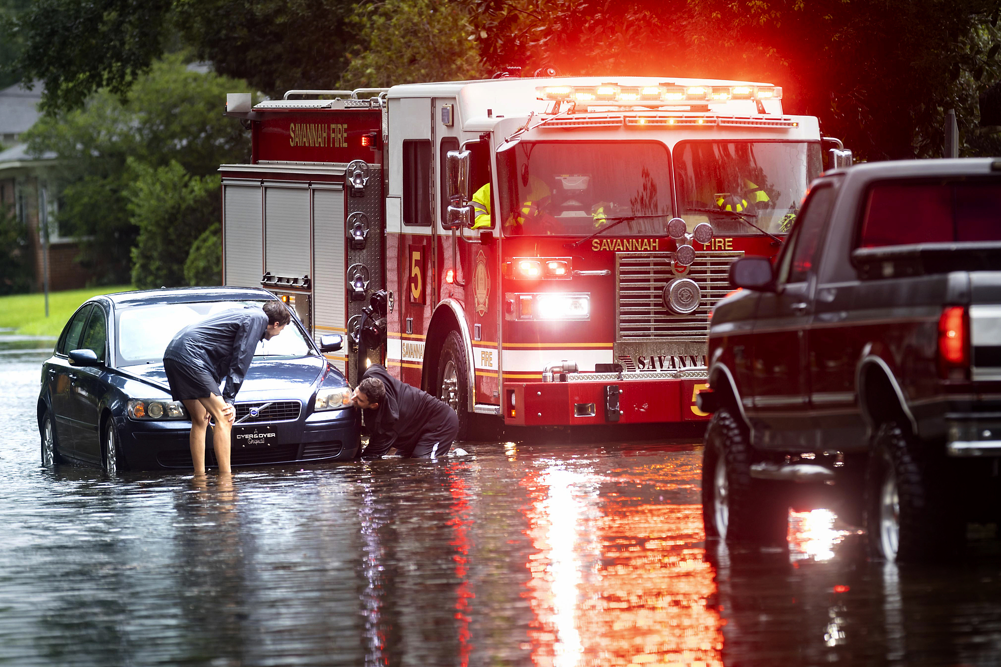 People attach a towline to a stranded vehicle on a flooded street after heavy rain from Tropical Storm Debby, in Savannah, U.S., August 5, 2024. /CFP