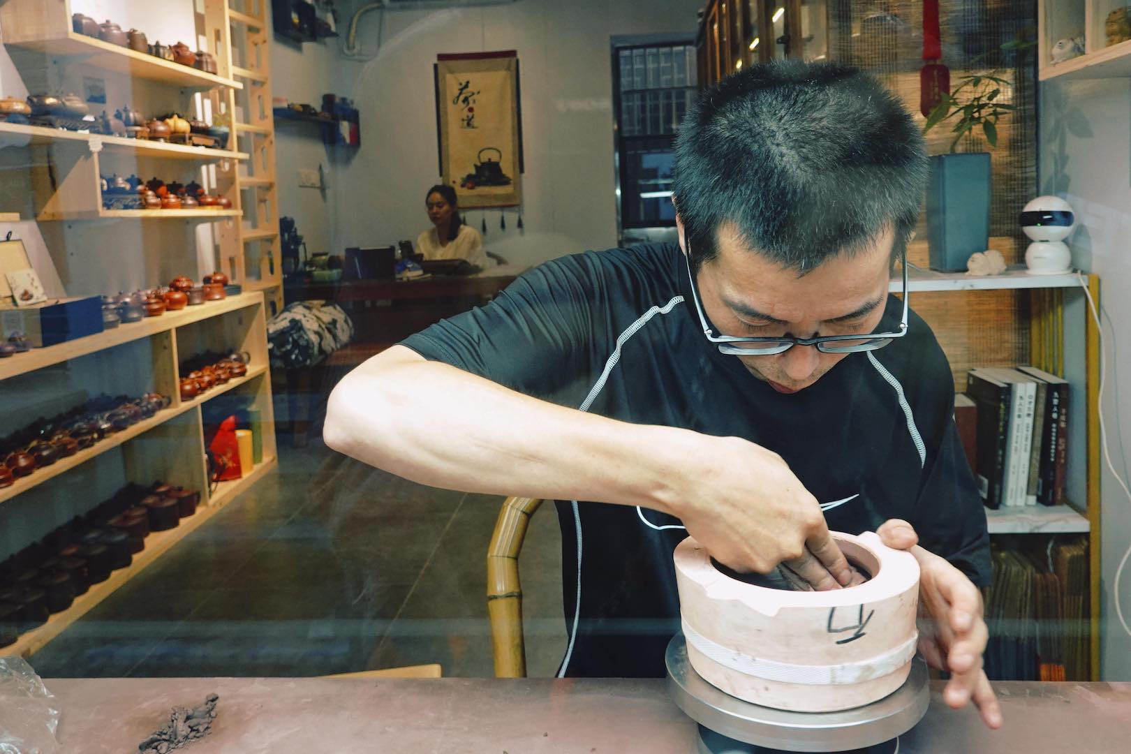 Artisans making purple clay tea ware are a common sight on Gunan Street in Yixing, Jiangsu Province. /CGTN